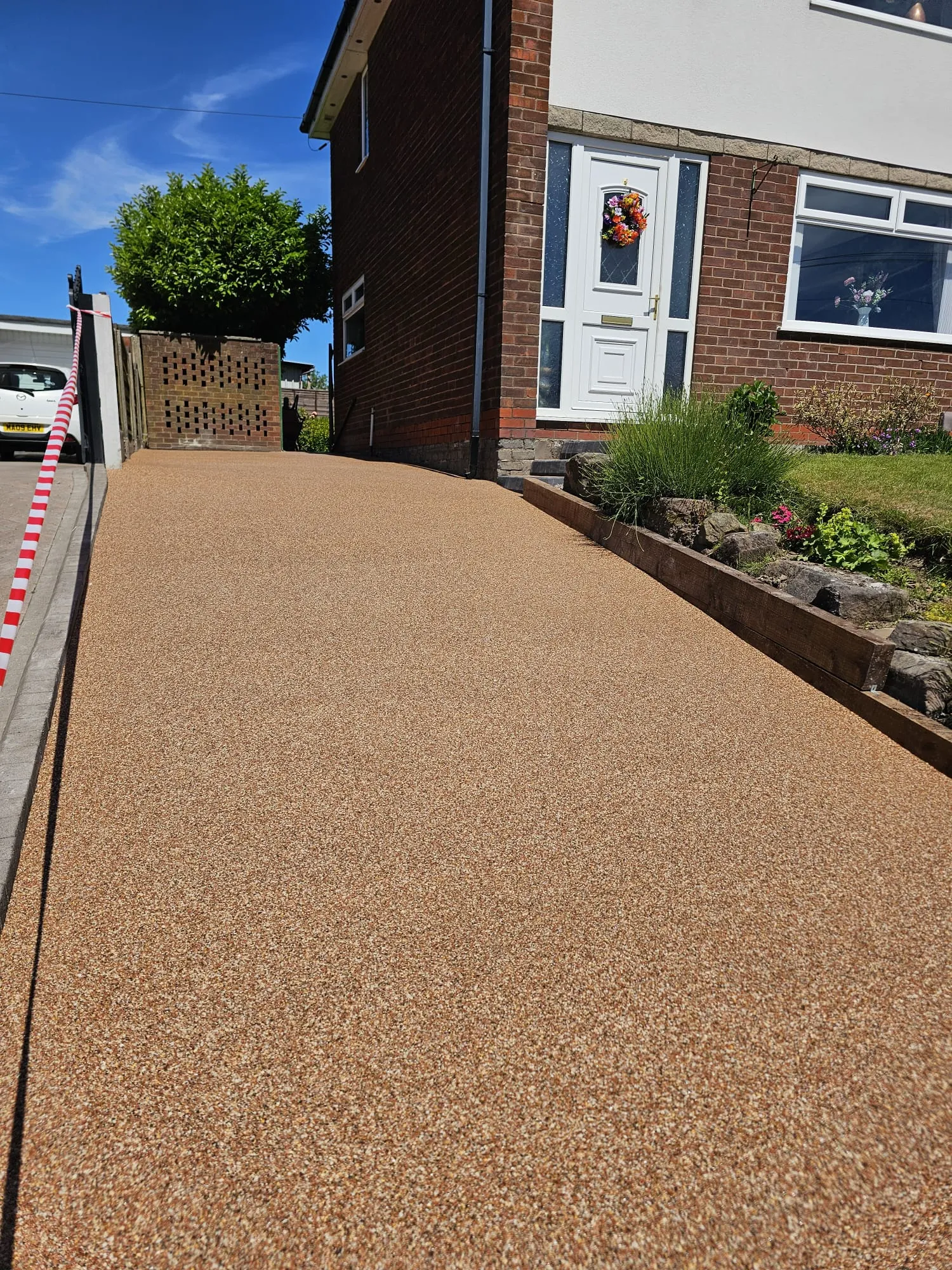 Golden resin-bound driveway outside a home
